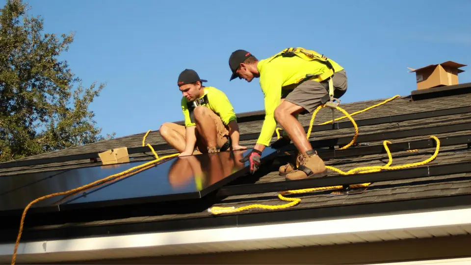 Techniciens posant des panneaux solaires sur un toit