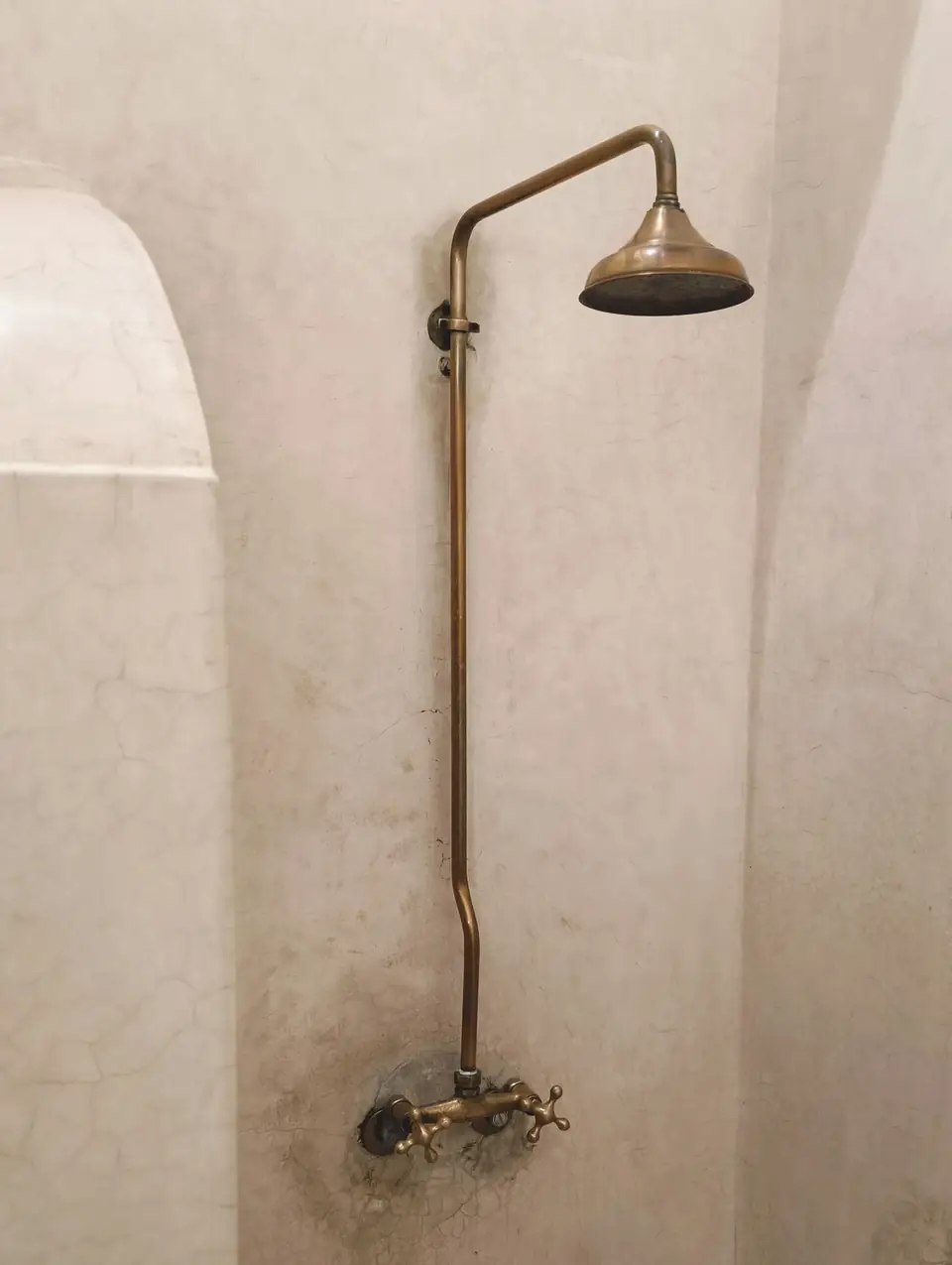 Douche en tadelakt beige avec colonne de douche en laiton